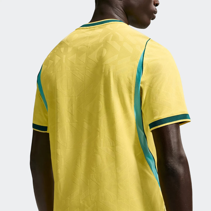 Back view of Brazil National Team 2026 Men's Nike Aero-Fit Home Soccer Jersey in yellow with geometric pattern, teal side