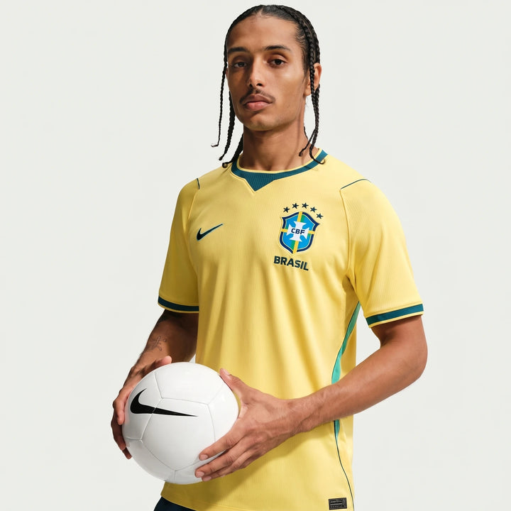 Yellow Brazil National Team 2026 Stadium Home Nike Dri-Fit soccer jersey for men, worn by a model holding a white soccer