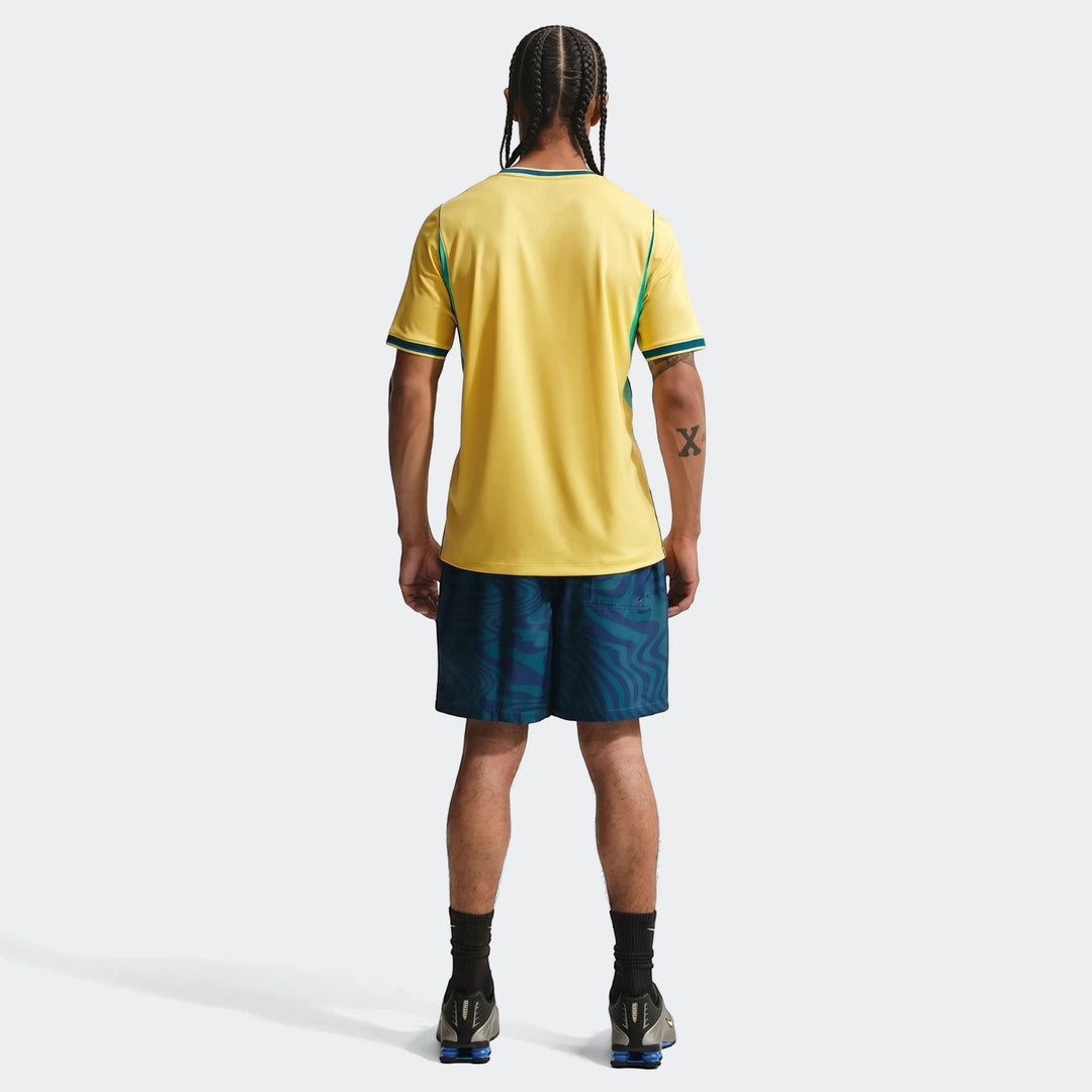 Brazil National Team 2026 Stadium Home Yellow Men's Nike Dri-Fit Soccer Jersey, shown from the back, paired with patterned
