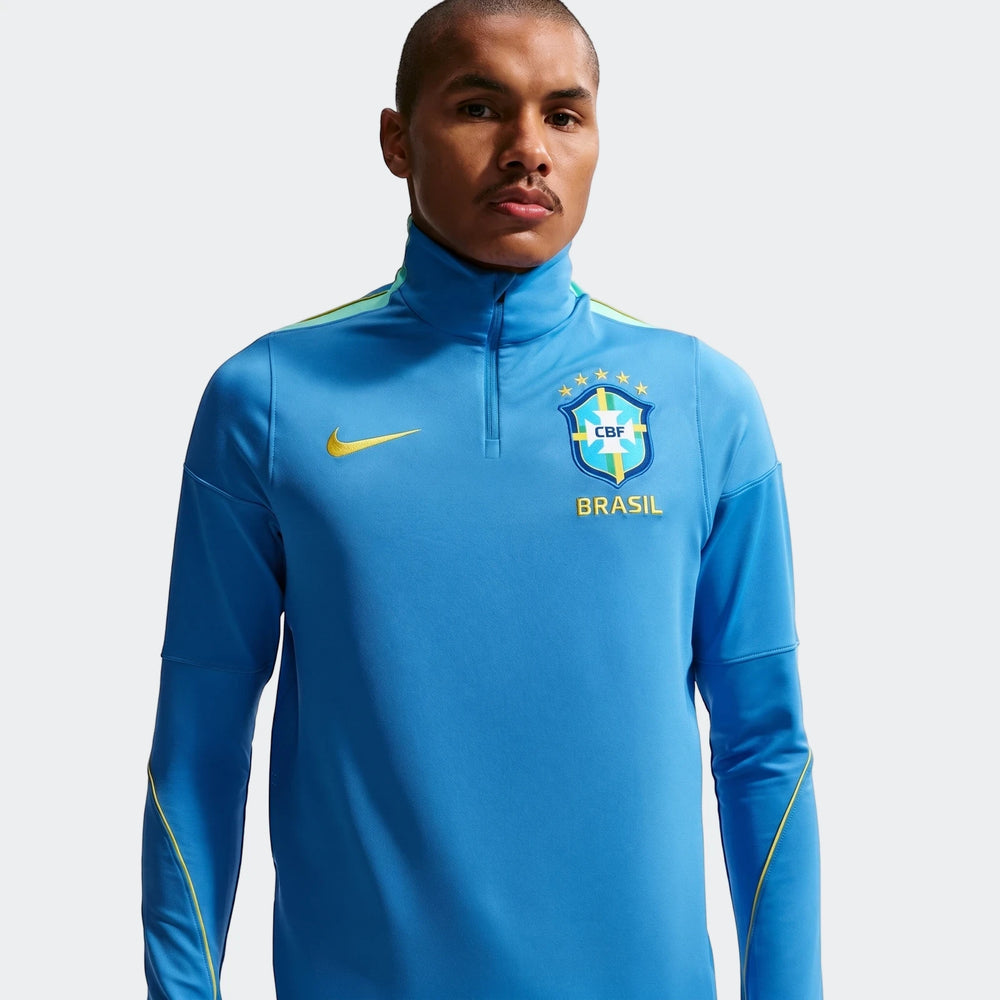 A male model wearing a blue Nike Brazil Strike Dri-Fit half-zip men's soccer drill top in a studio setting.