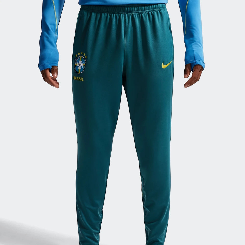 Men's Nike Brazil Strike Dri-Fit soccer knit pants in teal green, featuring the CBF logo and Nike swoosh. Front view on