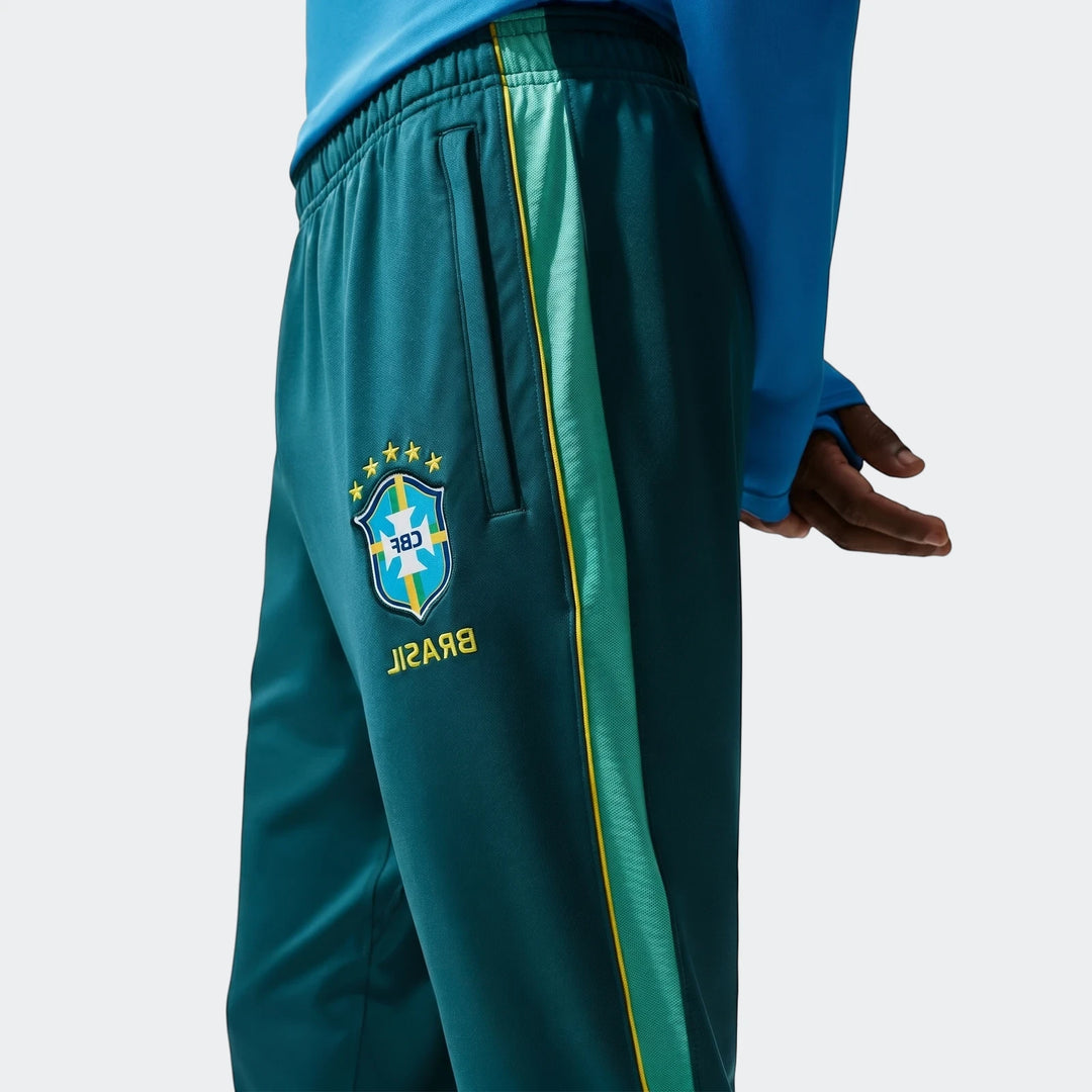 Close-up of Brazil Strike Green Men's Nike Dri-Fit Soccer Knit Pants, featuring the CBF logo and a side stripe, worn by a