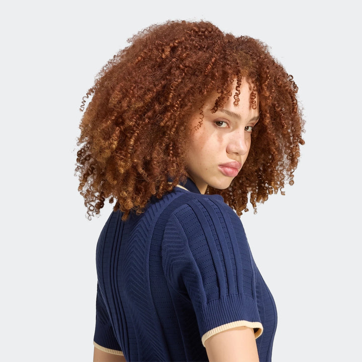 Cable Knit Cali Tee Polo in navy blue ribbed knit with cream trim, worn by a woman with curly red hair looking over her