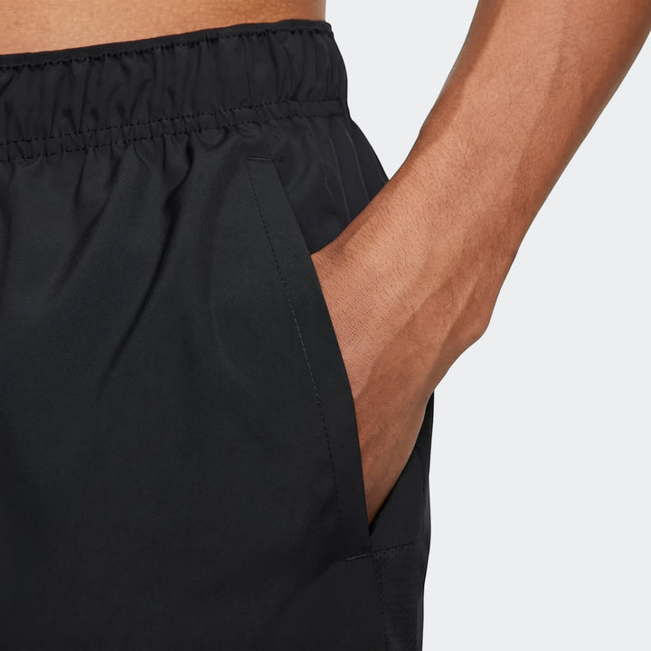 Close-up of black Challenger Men's Dri-Fit Unlined Running Shorts with an elastic waist and a hand in the pocket.