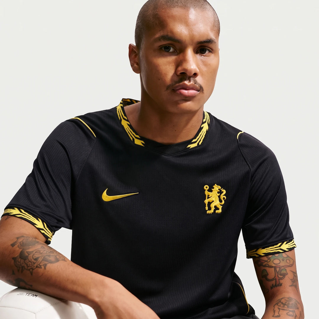 Man wearing a black Chelsea FC 2026/27 Stadium Away Nike Dri-Fit Soccer Replica Jersey with yellow accents and team crest.
