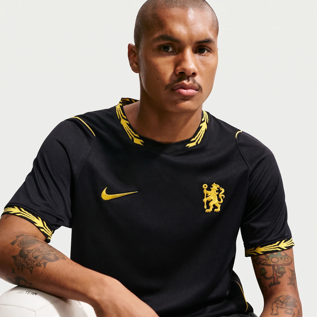 Man wearing a black Chelsea FC 2026/27 Stadium Away Nike Dri-Fit Soccer Replica Jersey with yellow accents and team crest.