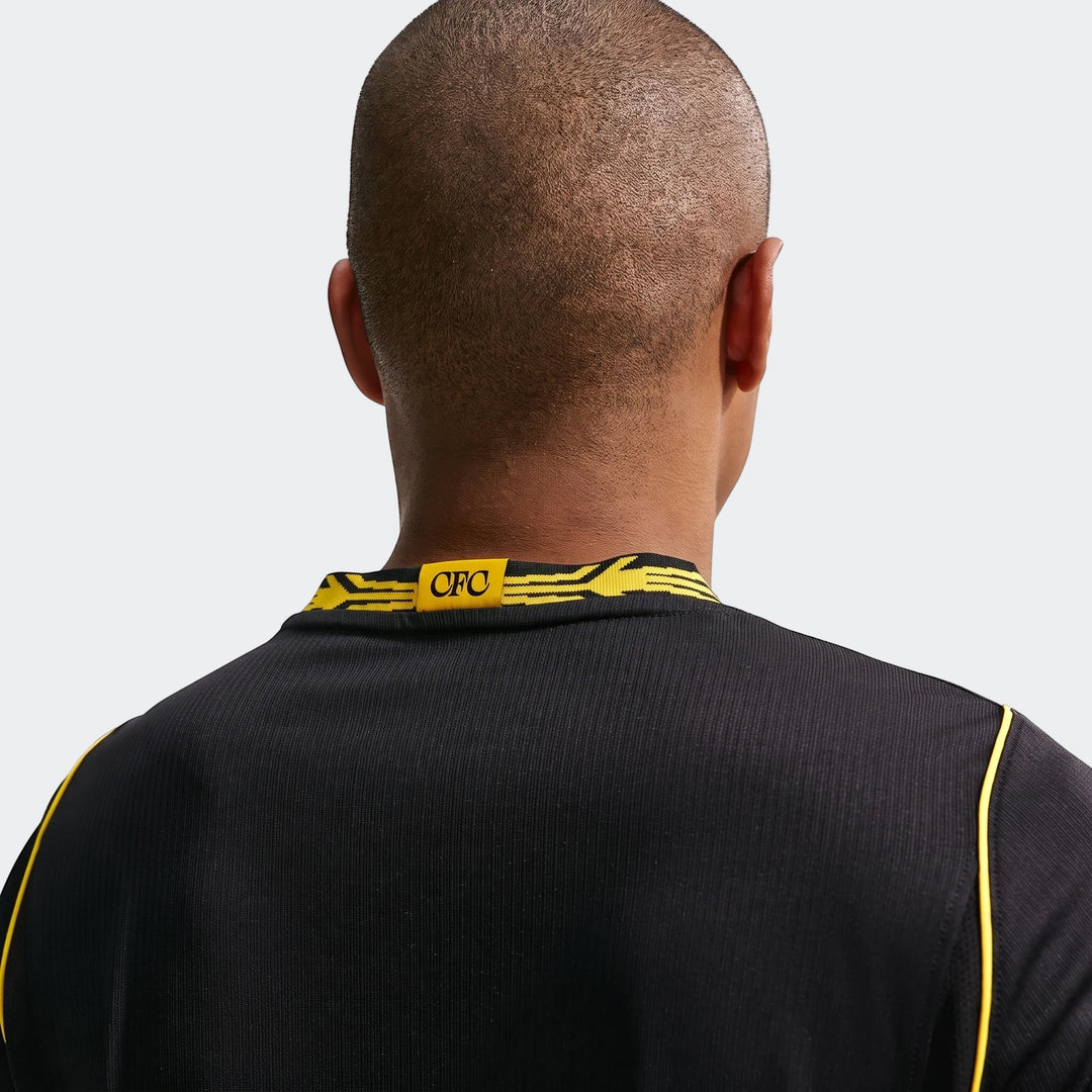 Back view of a man wearing the black Chelsea FC 2026/27 Stadium Away Nike Dri-Fit Soccer Replica Jersey with yellow trim.