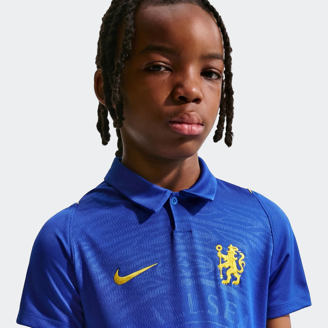 Young boy with dreadlocks wearing a blue Chelsea Fc 2026/27 Stadium Home Big Kids' Nike Dri-Fit Soccer Replica Jersey