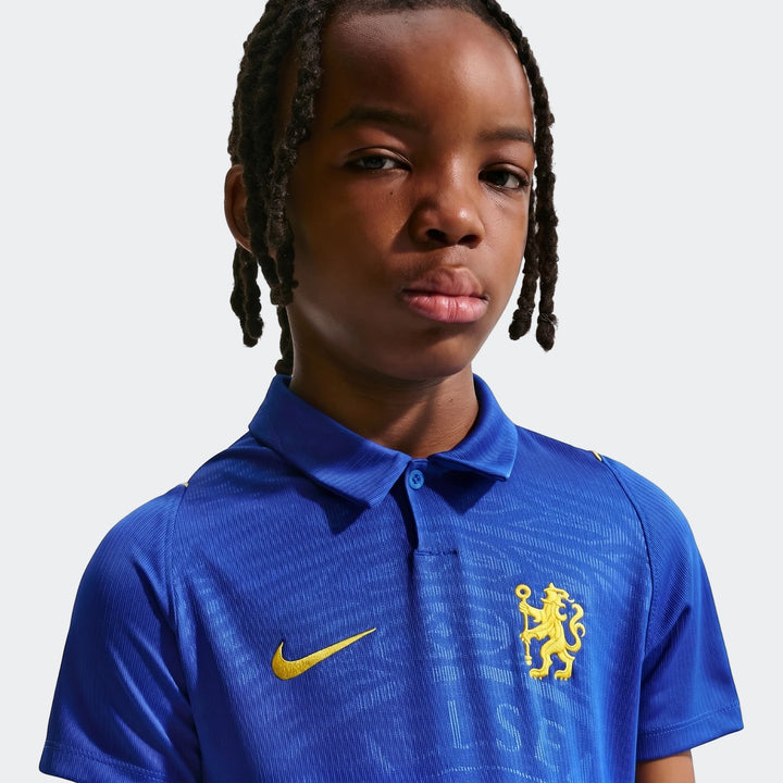 Young boy with dreadlocks wearing a blue Chelsea Fc 2026/27 Stadium Home Big Kids' Nike Dri-Fit Soccer Replica Jersey