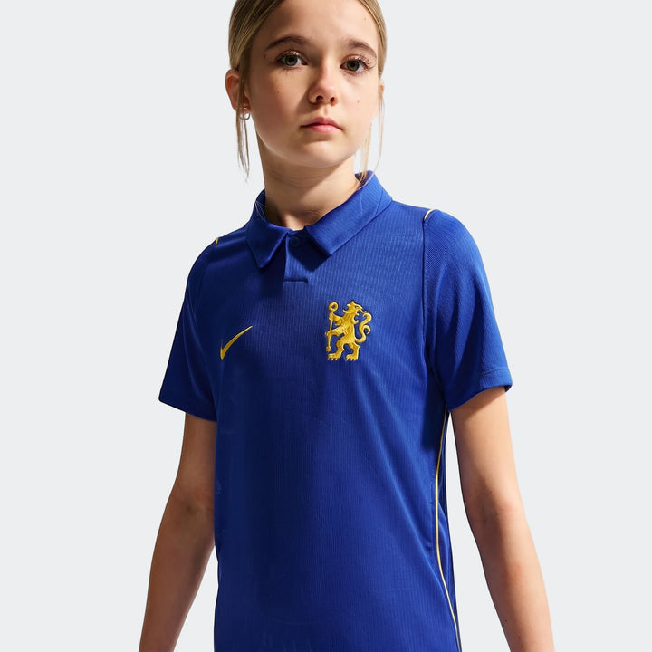 Young girl wears a blue Chelsea FC 2026/27 Stadium Home Big Kids' Nike Dri-Fit Soccer Replica Jersey, displaying the Nike