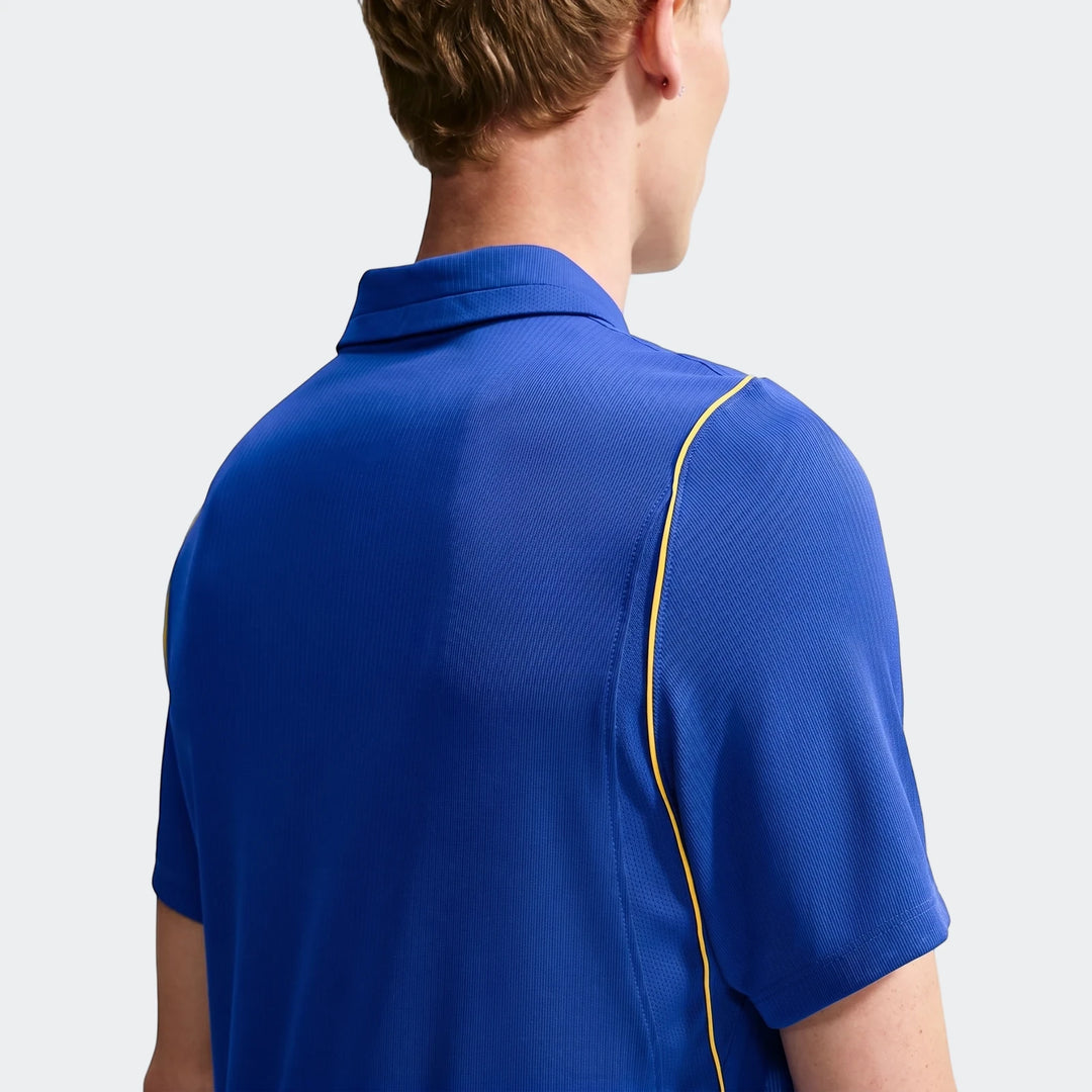 Rear view of a man wearing a blue Nike Dri-Fit Chelsea FC 2026/27 Stadium Home soccer jersey with yellow accents.