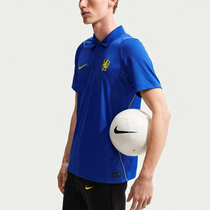 Men's Chelsea FC 2026/27 Stadium Home blue Nike Dri-FIT soccer replica jersey worn by a model holding a soccer ball.