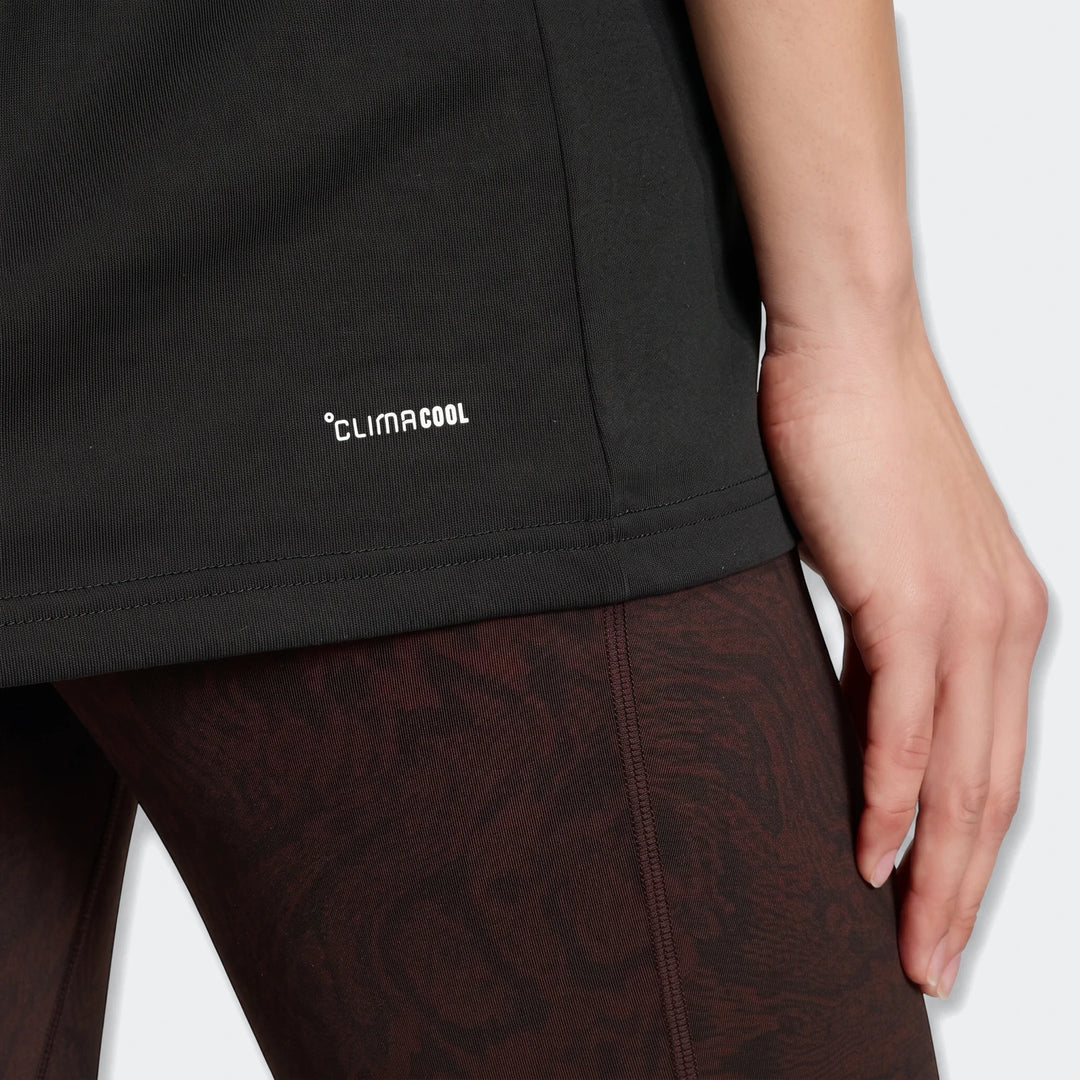 Close-up of a person wearing a black Adidas Climacool t-shirt and patterned training leggings, featuring the Climacool logo.