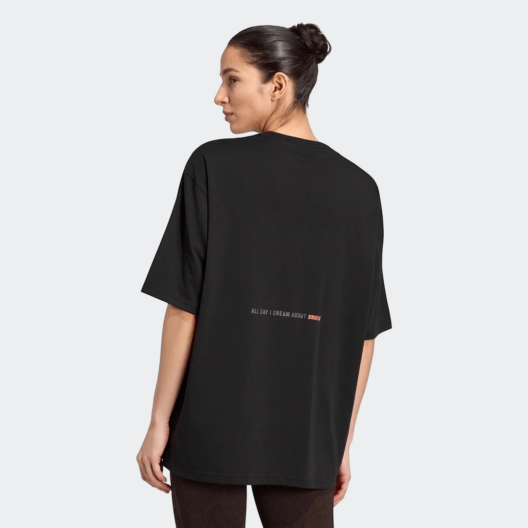 Back view of a woman wearing an oversized black Climacool Animal Training Graphic T-Shirt with 'ALL DAY I DREAM ABOUT TRAIN'