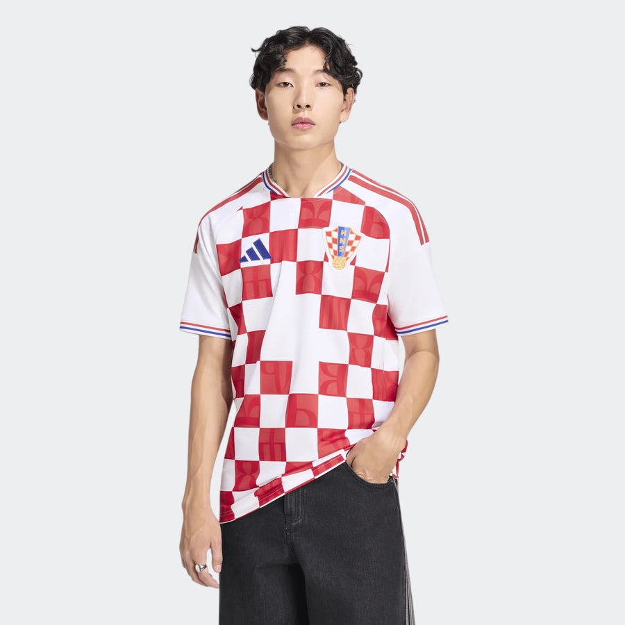 Male model wearing a red and white checkerboard Croatia 26 Home Jersey and black pants, captured in a studio shot.