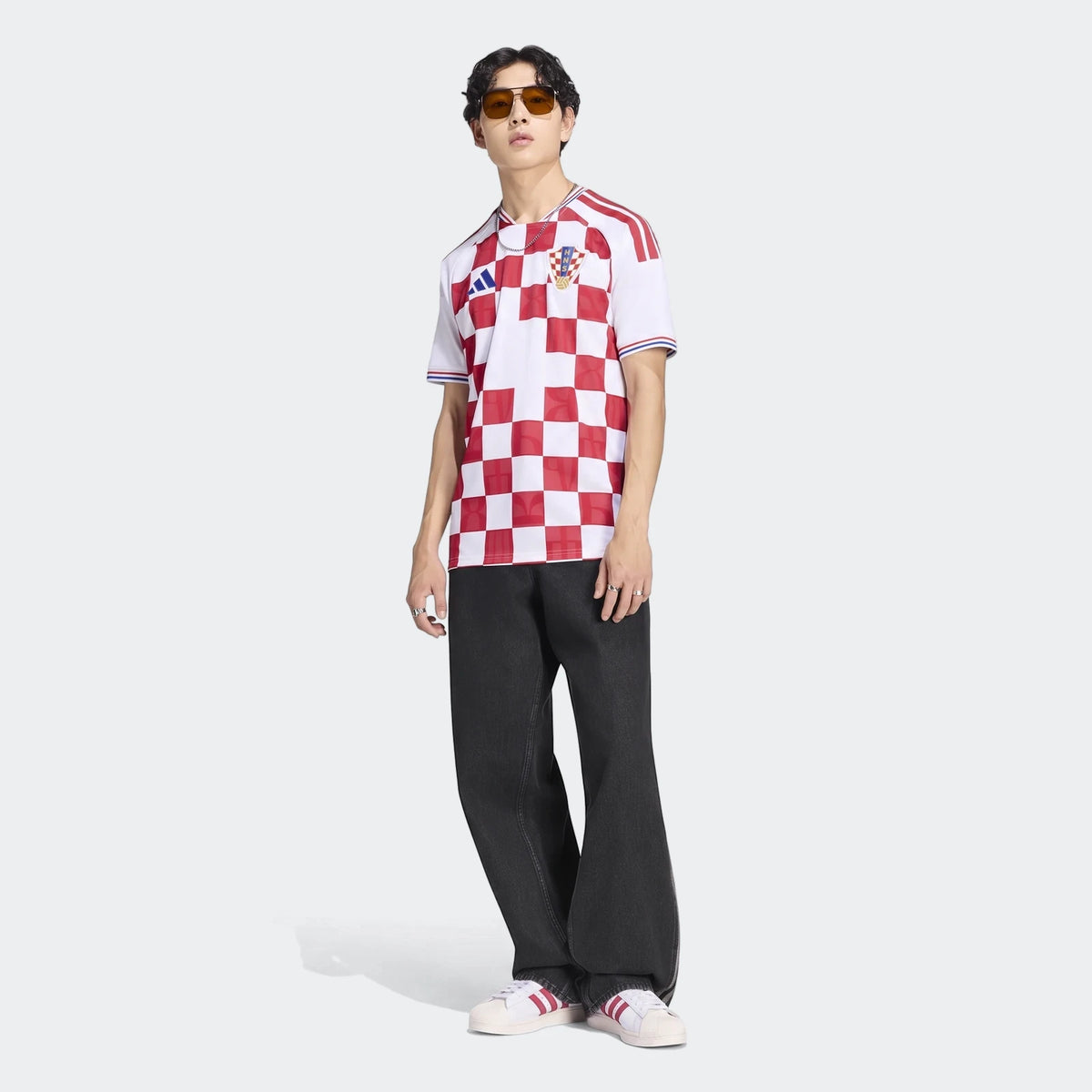 Model wearing the white and red checkerboard Croatia 26 Home Jersey, paired with black wide-leg jeans and white sneakers.