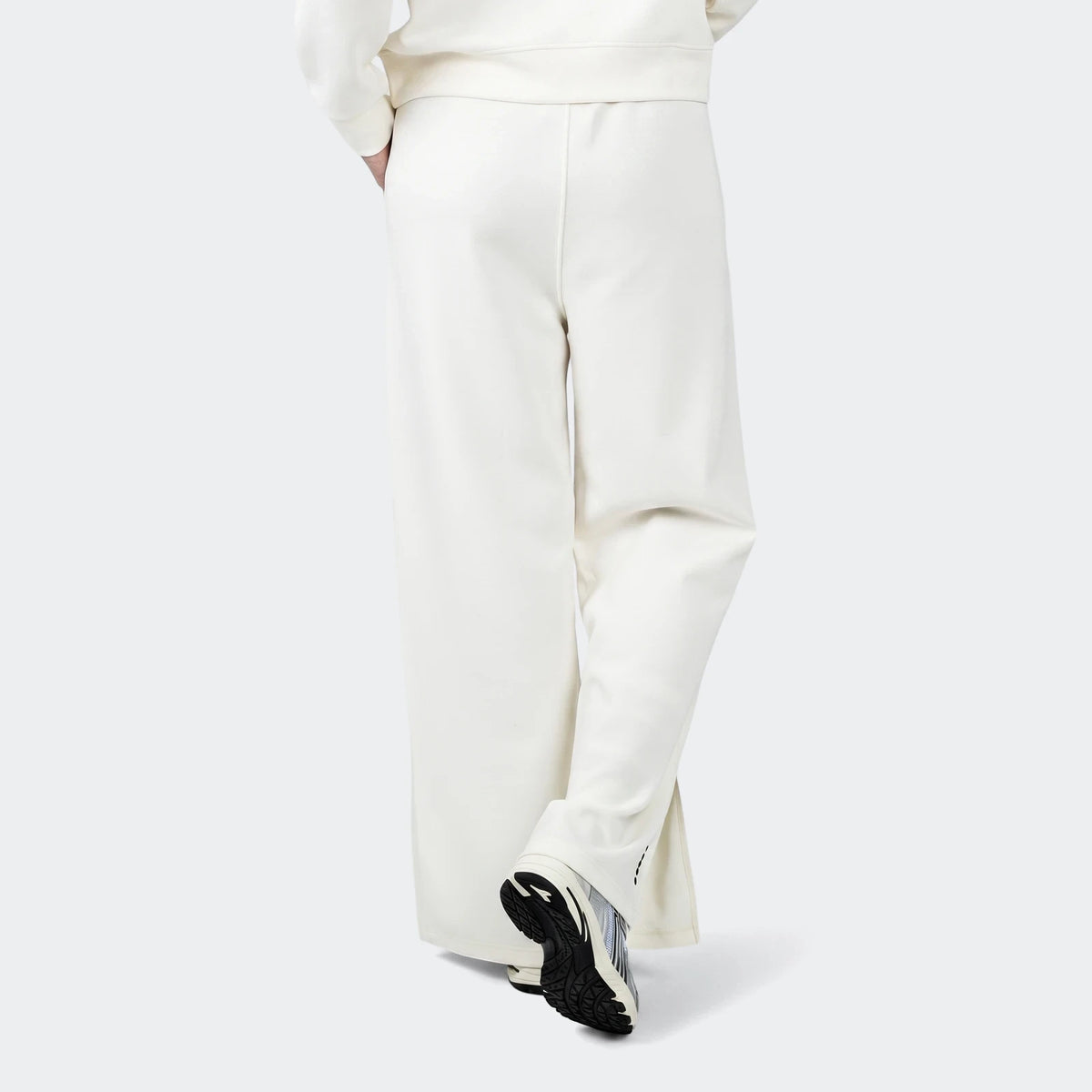 Cream wide-leg Danielle Trackpant, shown from behind, featuring a relaxed fit. Styled with athletic sneakers.