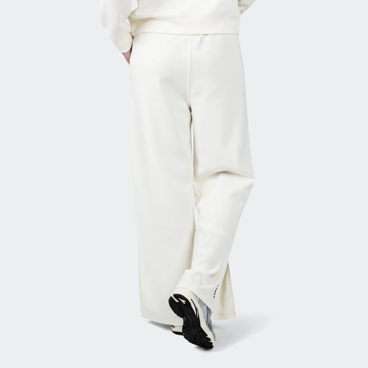 Cream wide-leg Danielle Trackpant, shown from behind, featuring a relaxed fit. Styled with athletic sneakers.