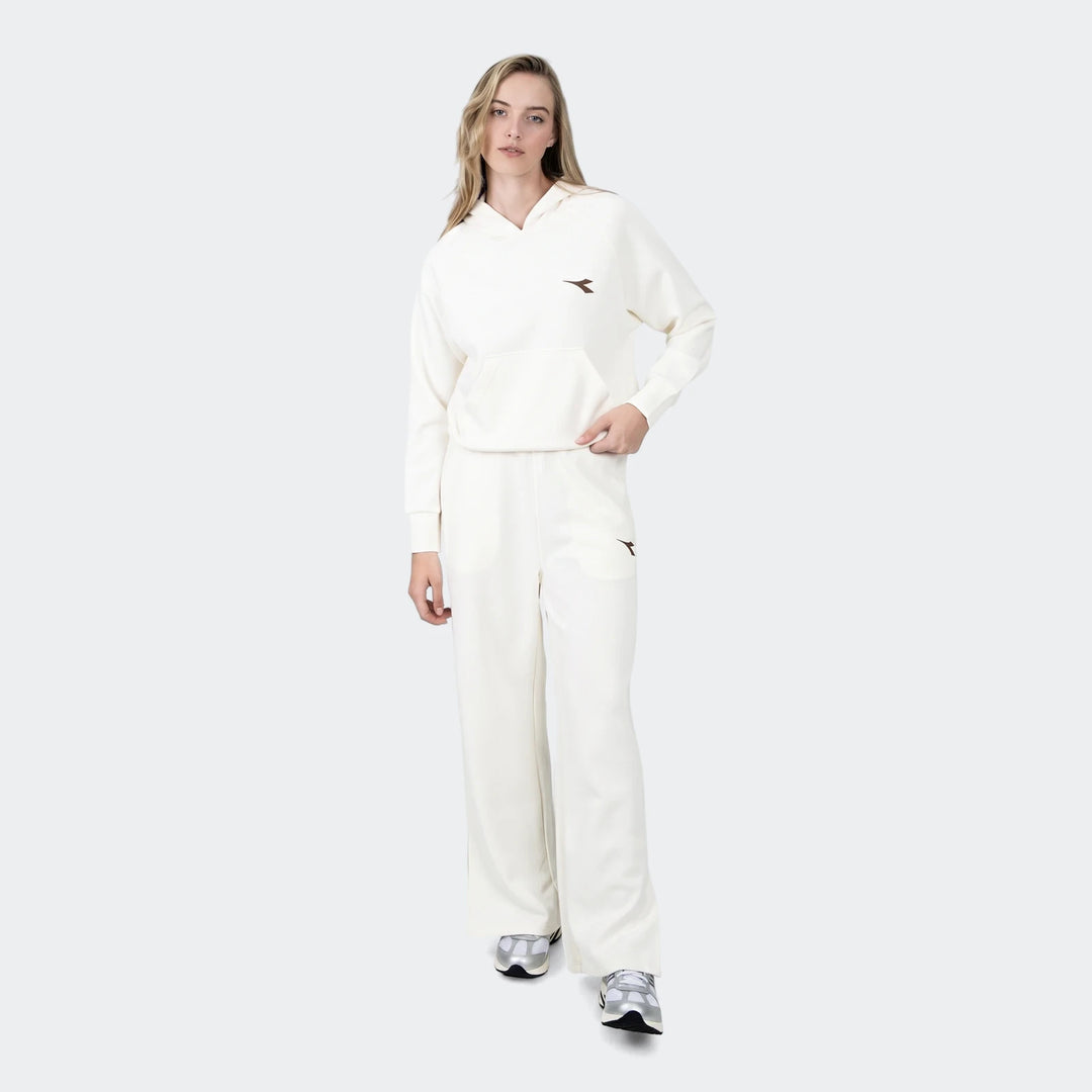 Female model wearing an off-white Danielle Trackpant set, including a hoodie with a kangaroo pocket and wide-leg trackpants,