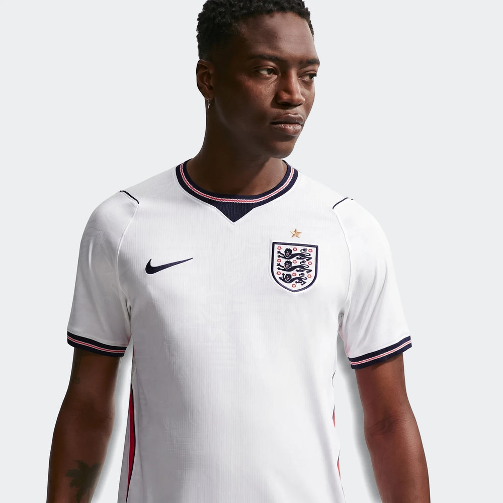 A model wears the England National Team 2026 Stadium Home White Men's Nike Dri-Fit Soccer Jersey, featuring a V-neck and
