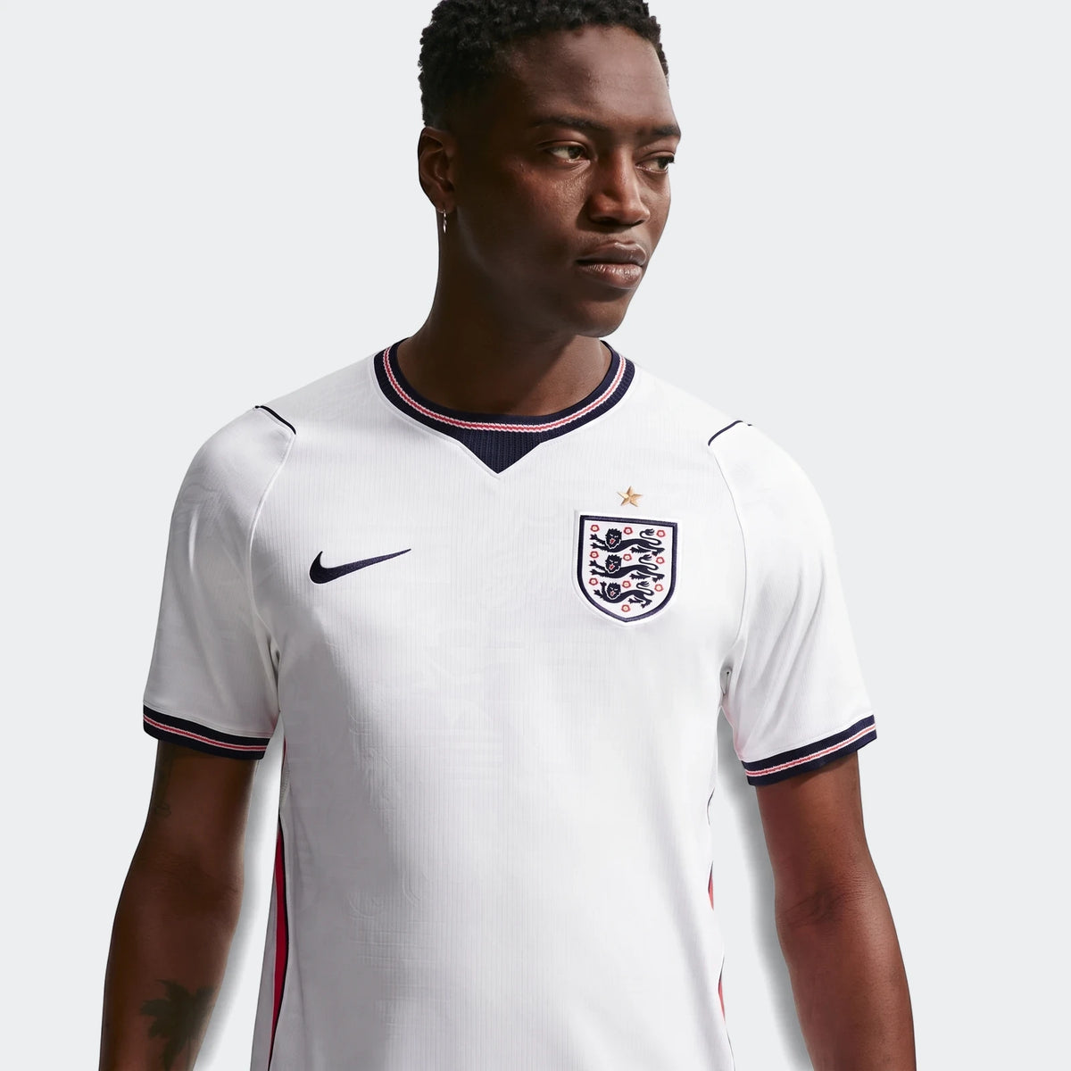 A model wears the England National Team 2026 Stadium Home White Men's Nike Dri-Fit Soccer Jersey, featuring a V-neck and