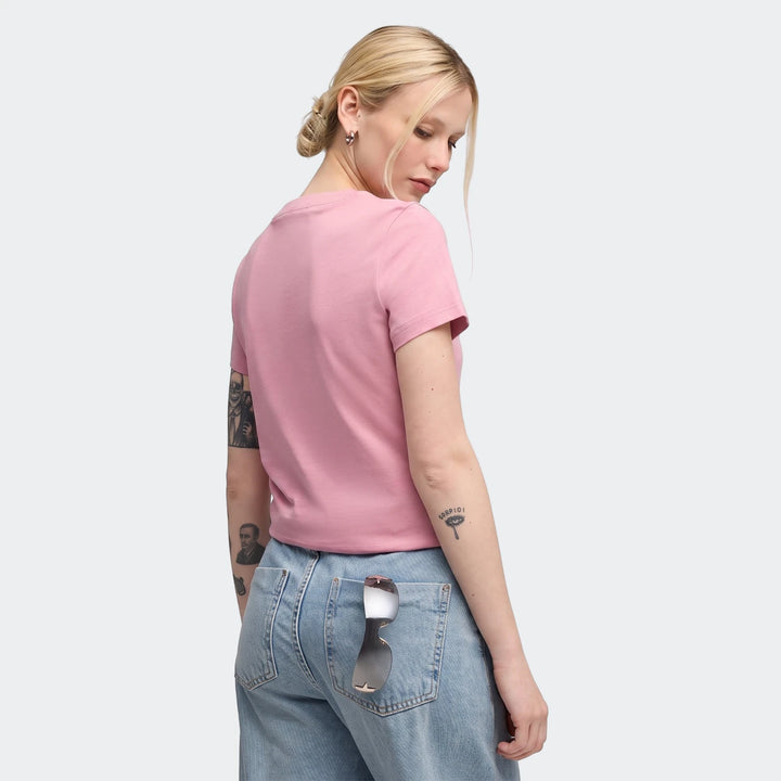 Pink short-sleeved Ess Elevated Tee W worn by a woman with blonde hair, seen from the back, paired with light wash jeans.