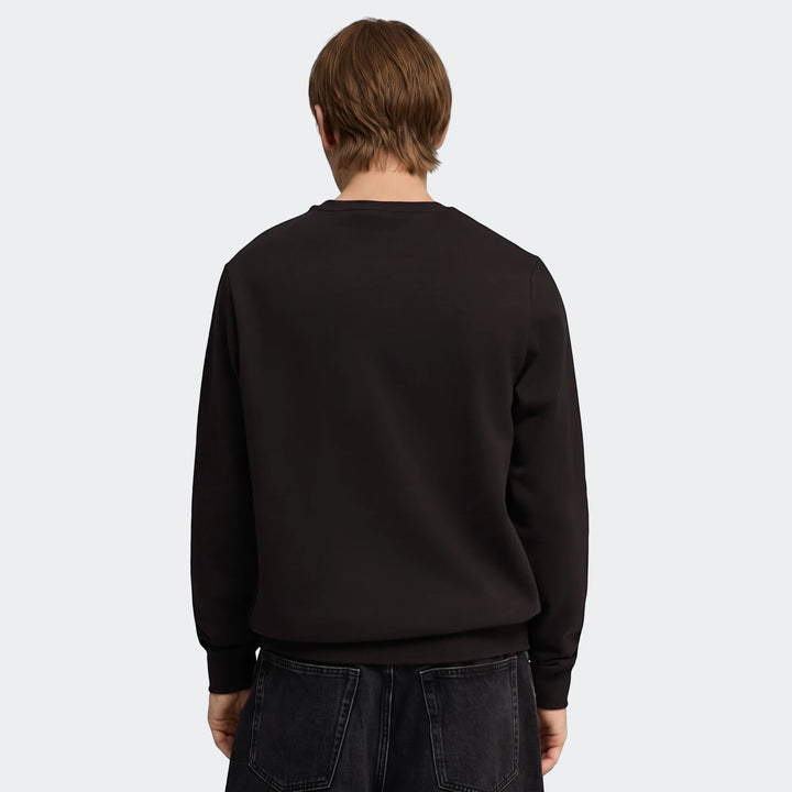Back view of a male model wearing a black Ess No.1 Logo Crew Sweatshirt and dark jeans against a grey background.