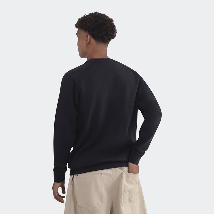 Male model from back wearing dark navy Essentials Crew Sweatshirt and light beige shorts with an embroidered logo, looking