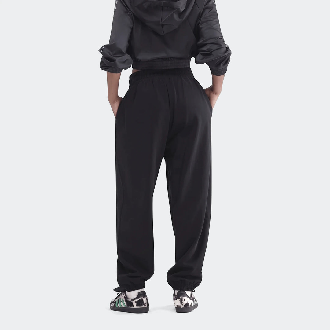 Black Essentials French Terry Jogger Pants on a model, shown from the rear view, highlighting the relaxed fit.