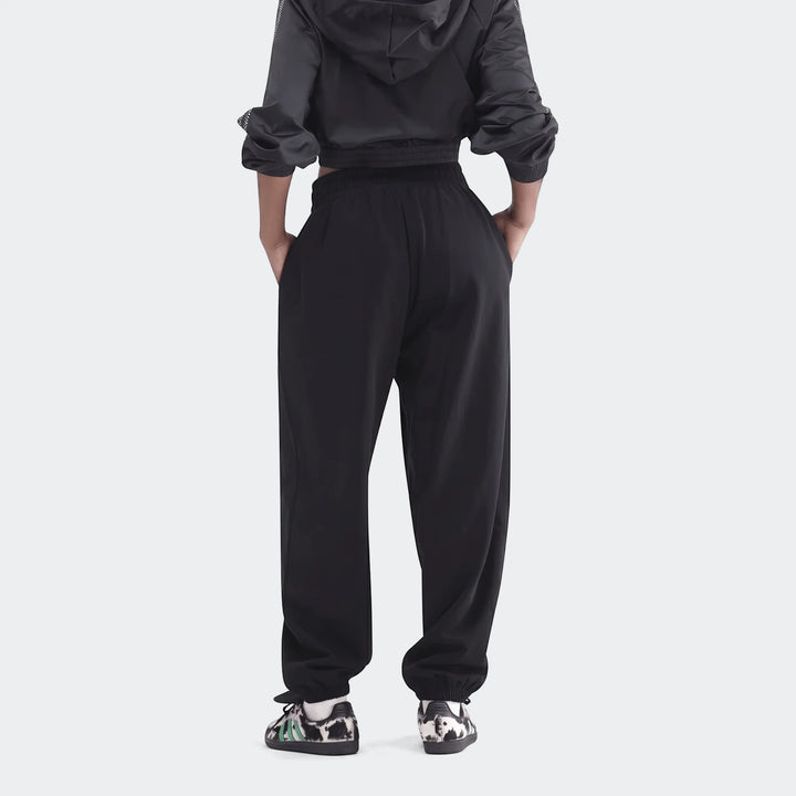 Black Essentials French Terry Jogger Pants on a model, shown from the rear view, highlighting the relaxed fit.