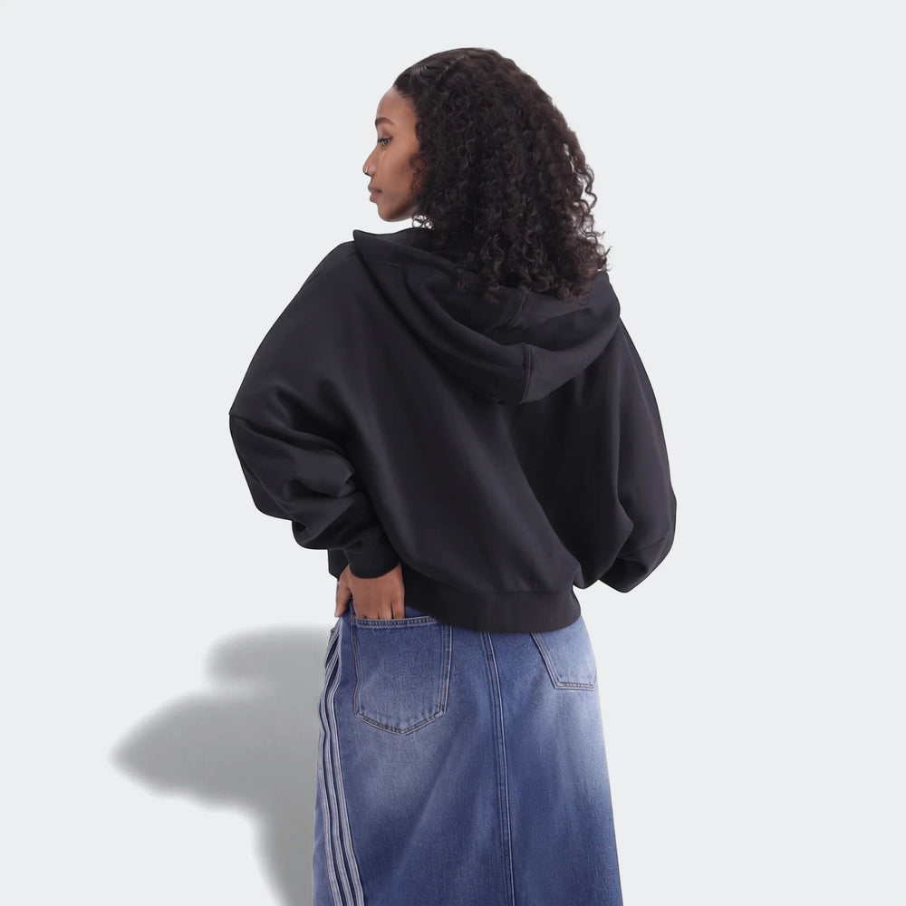 Model wearing a black Essentials Full-Zip Hoodie and a blue denim skirt, viewed from the back.