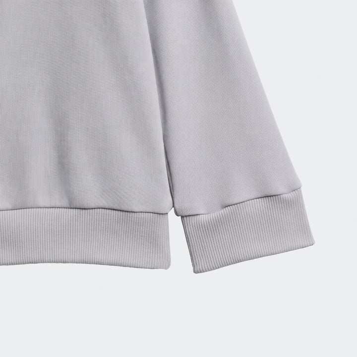 Light grey Essentials Kids long-sleeved top with ribbed cuffs and hem, showcasing the knit fabric texture.