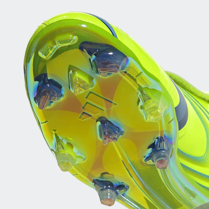 Close-up of the sole of a neon yellow-green F50 Elite FG Tunit football boot, showcasing iridescent studs and Adidas