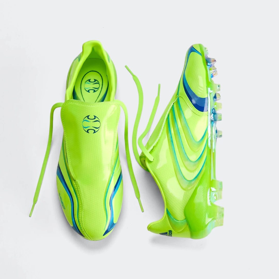 Pair of bright neon green F50 Elite Fg Tunit football boots with blue and teal wave patterns, shown from a top-down view