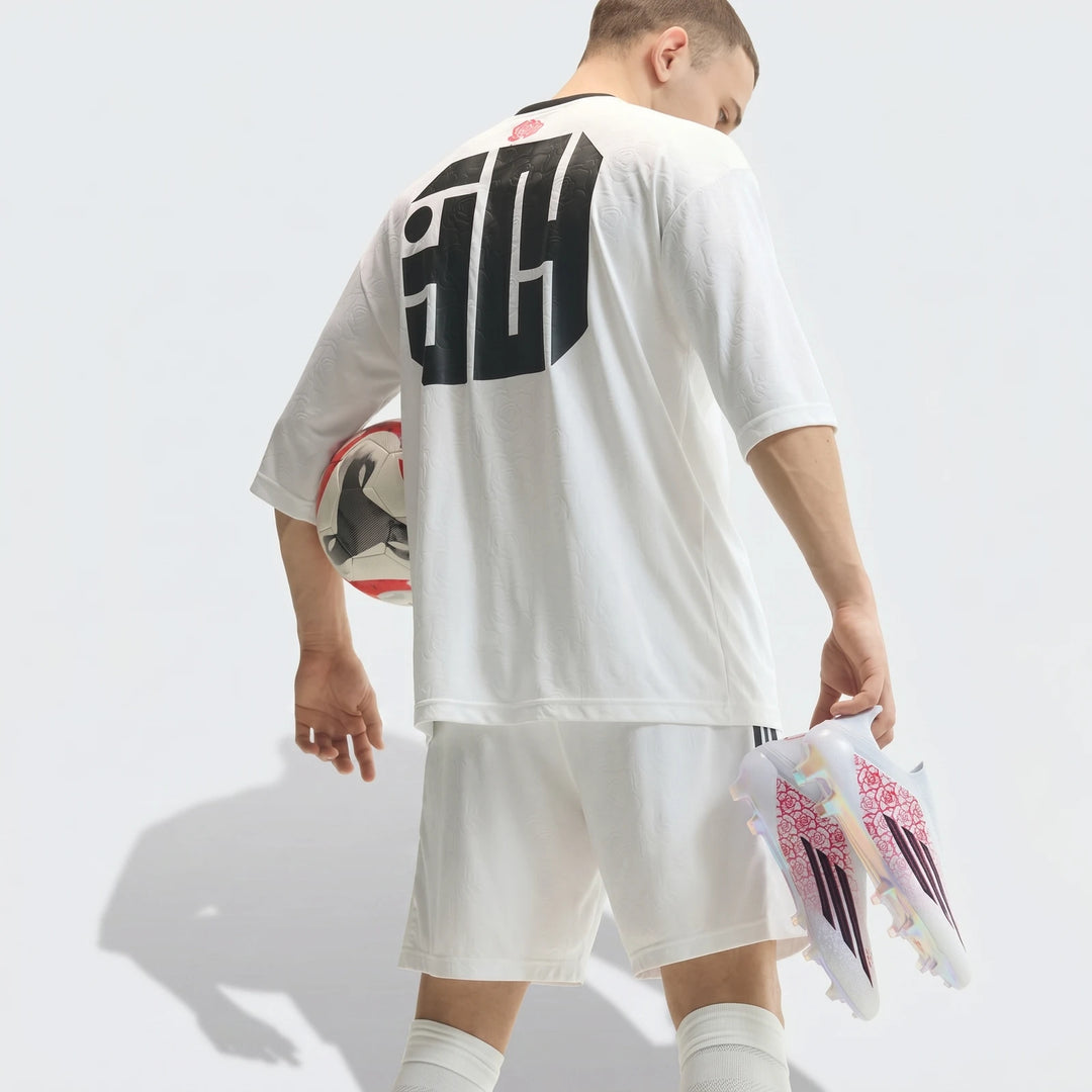 Male soccer player in white uniform holding a soccer ball and white, red, and black F50 Elite Ll Fg Lamine Yamal Football
