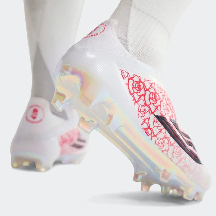 White F50 Elite Ll Fg Lamine Yamal football boots with red rose pattern and iridescent soles, worn on feet.