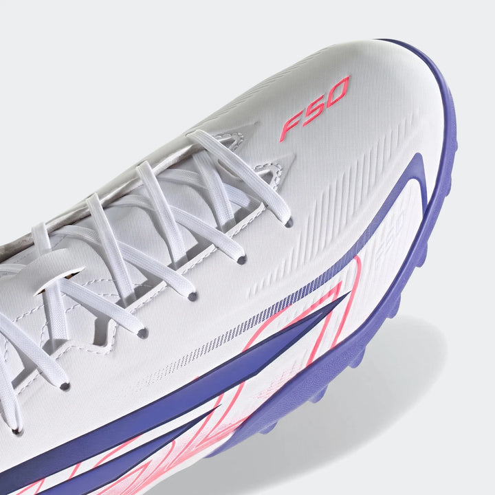 Close-up of a white Adidas F50 Hyperfast Club Turf Football Shoe, featuring pink F50 logo and purple studded sole.