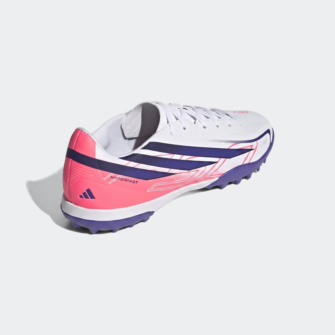 F50 Hyperfast Club Turf Football Shoes in white, pink, and navy, featuring a studded purple sole, shown from a rear-quarter