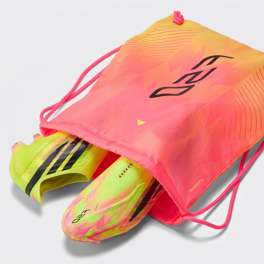Close-up of F50 Hyperfast Elite Laceless Firm Ground Boots in neon yellow and pink, stored in a matching pink and orange