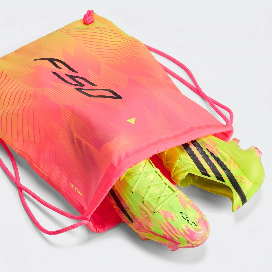 Neon yellow-green Adidas F50 Hyperfast Elite Firm Ground Football Boots with a pink and orange F50 drawstring bag, shown