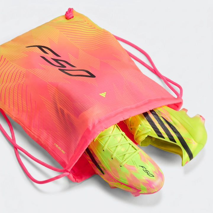 Neon yellow-green Adidas F50 Hyperfast Elite Firm Ground Football Boots with a pink and orange F50 drawstring bag, shown