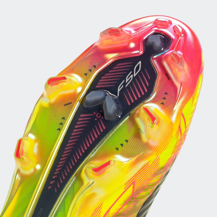 Close-up of the sole of an F50 Hyperfast Elite Laceless Firm Ground Boot, featuring a vibrant yellow, orange, and pink