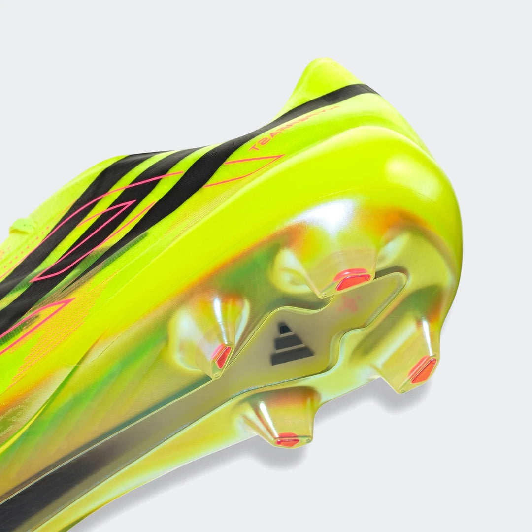 Close-up of a vibrant neon yellow F50 Hyperfast Evo firm ground football boot, showcasing the iridescent soleplate with