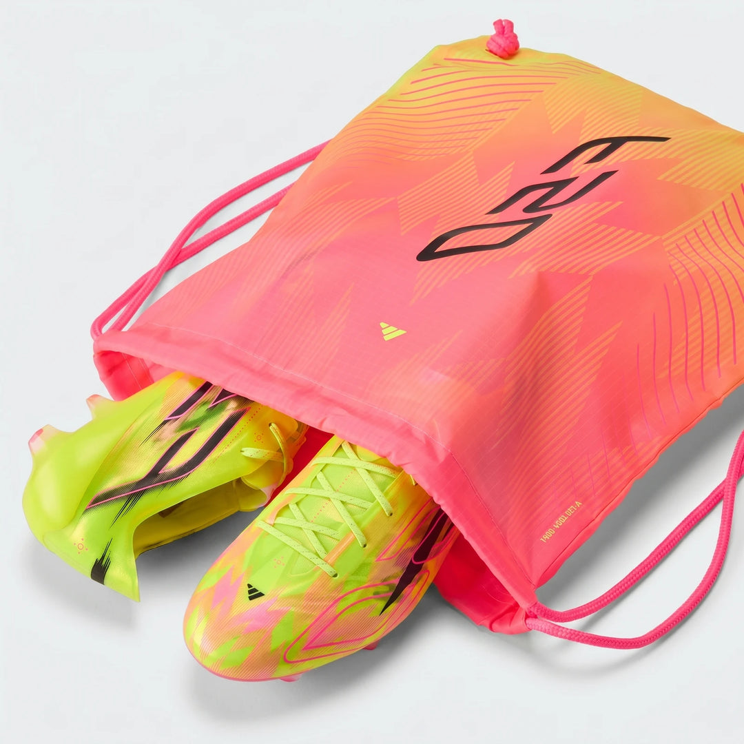 F50 Hyperfast Evo Firm Ground Football Boots in neon yellow, pink, and black, partially inside a matching drawstring bag,