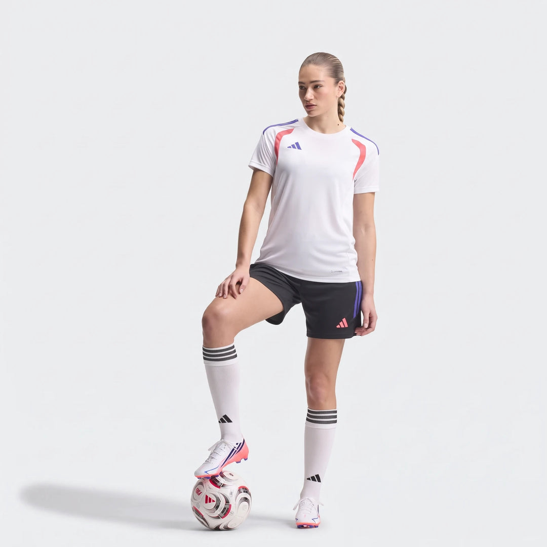 Female model wearing white F50 Hyperfast League Firm Ground Football Boots, black shorts, and a white athletic top, with a