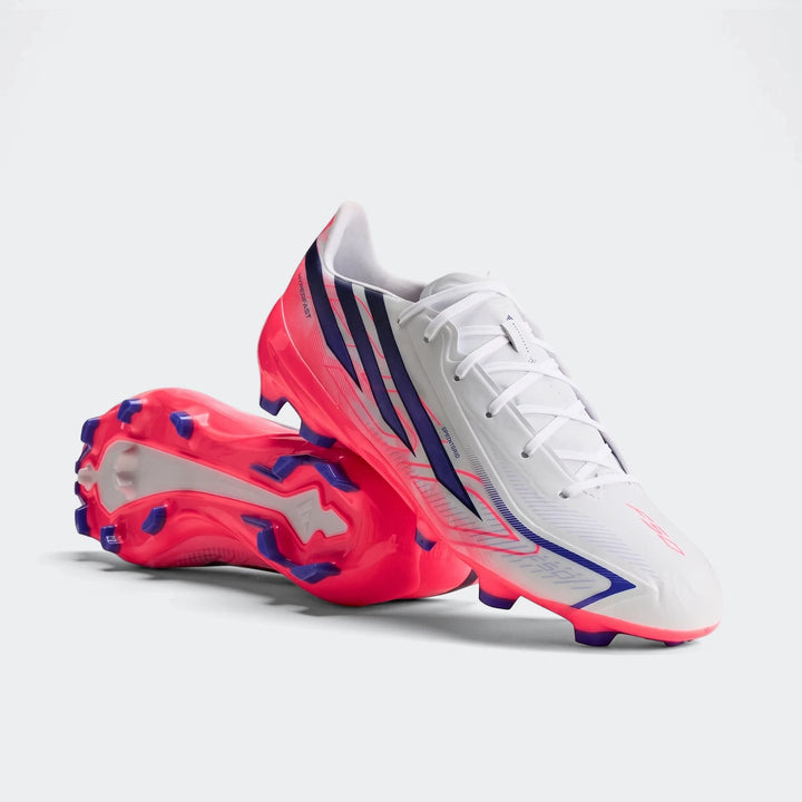 A pair of white, pink, and blue Adidas F50 Hyperfast League Firm Ground Football Boots with vibrant soles, photographed on a