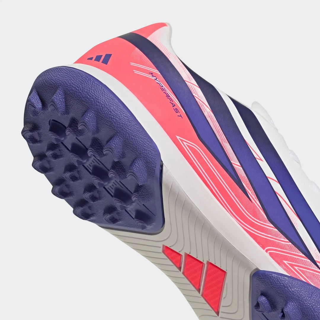 Kids' F50 Hyperfast Club Turf Football Boot in pink, blue, and white, with a purple studded turf sole, captured in a dynamic