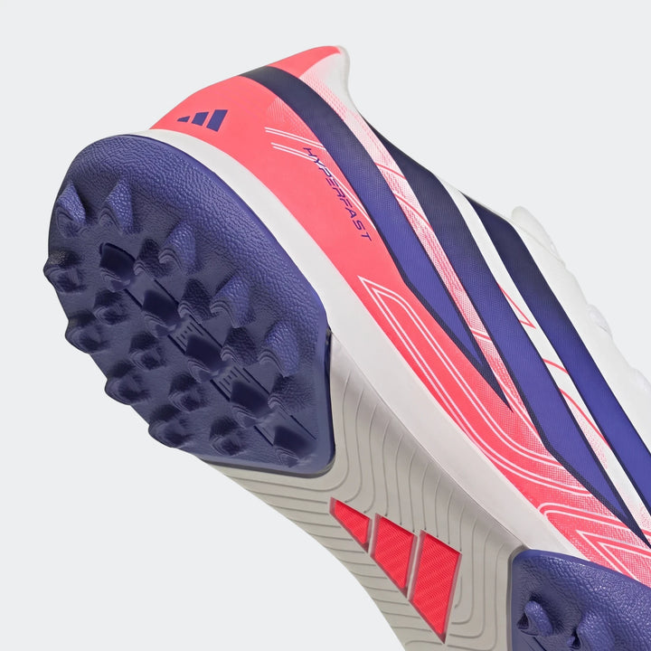 Kids' F50 Hyperfast Club Turf Football Boot in pink, blue, and white, with a purple studded turf sole, captured in a dynamic