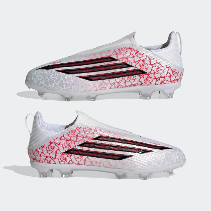 Two white Adidas F50 League Ll Fg / Mg Lamine Yamal kids football boots with red rose patterns and black stripes, side view.