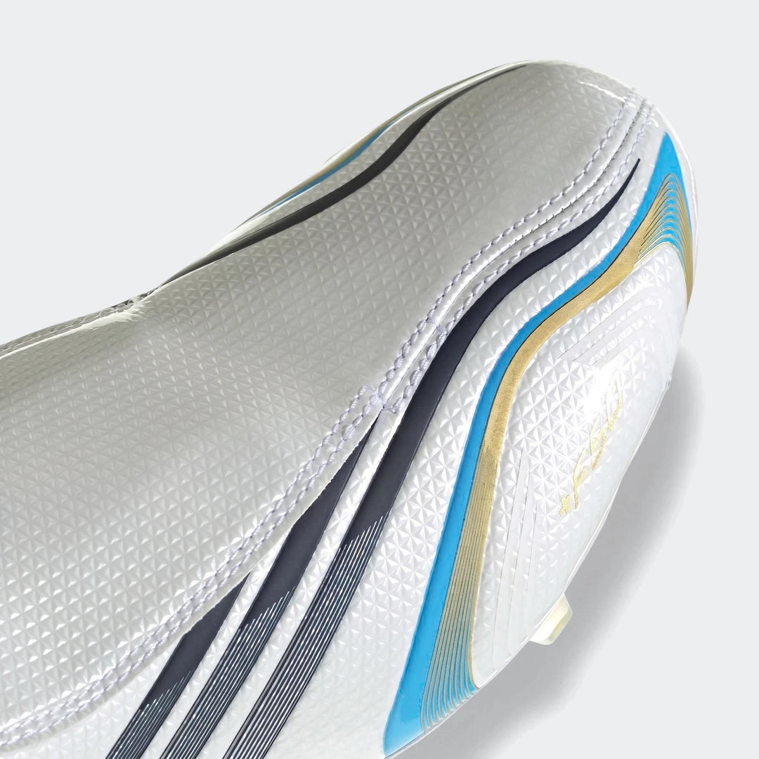 Close-up of a white F50 Tunit Firm Ground Football Boot featuring black, blue, and gold stripe details and a textured upper.